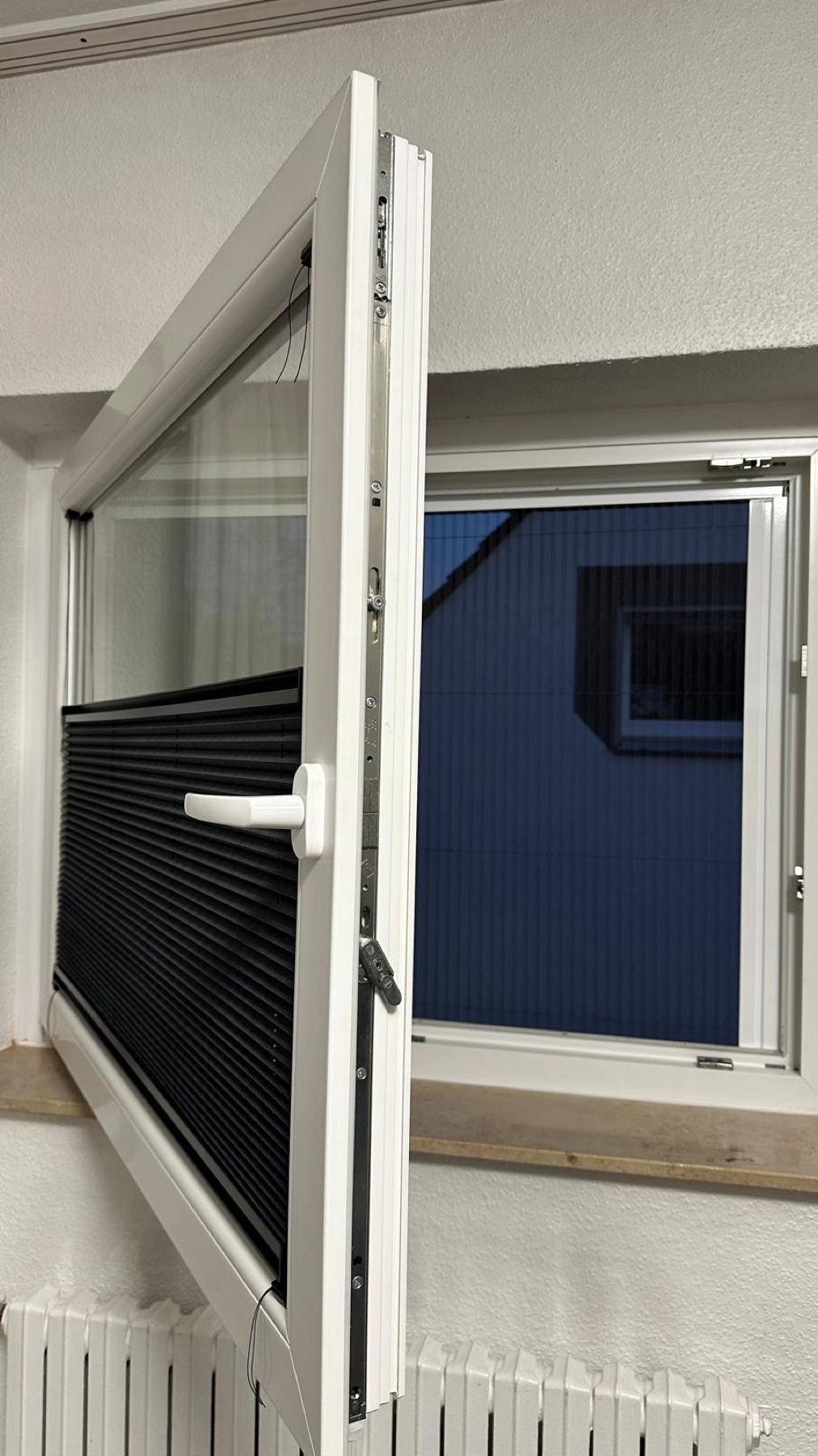 Geöffnetes Fenster mit schwarzem Plissee Insektenschutz